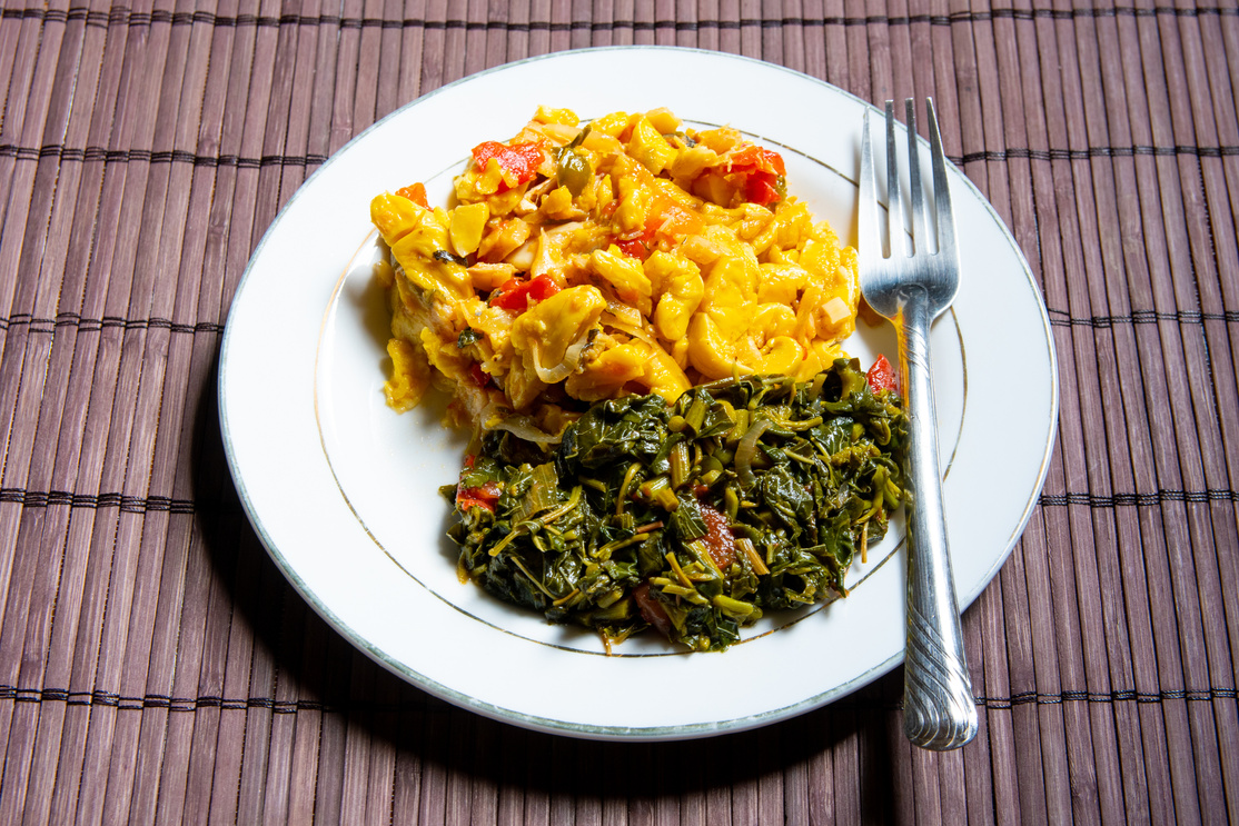 Famous traditional Jamaican ackee & saltfish breakfast, steamed callaloo seasoned with tomatoes, thyme, onions, escallion (scallion).
